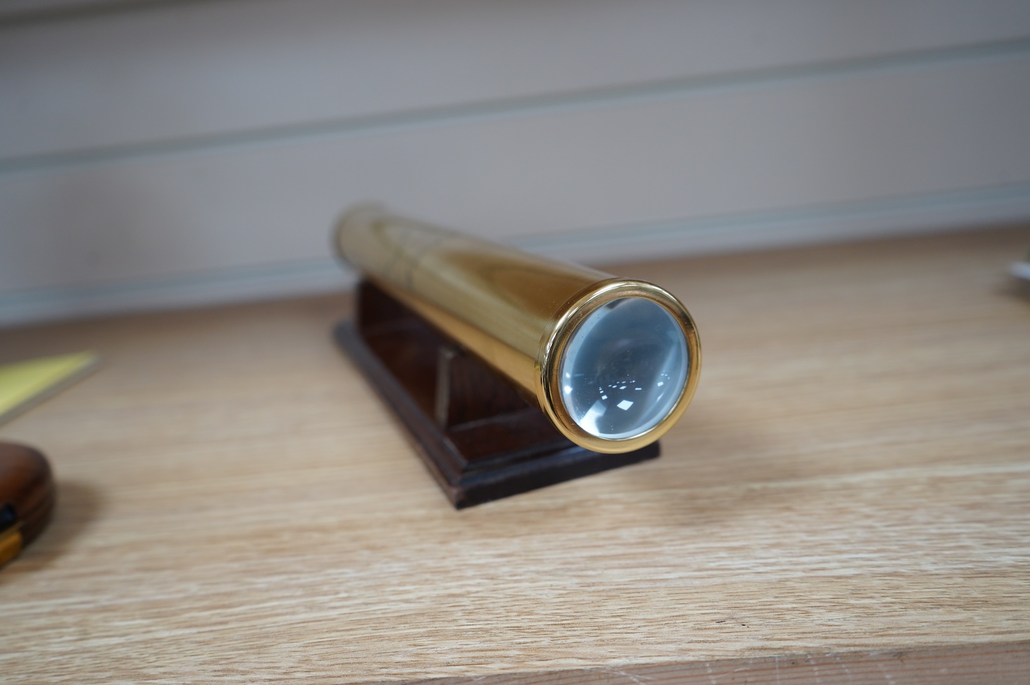 A reproduction 19th century style brass kaleidoscope by Culpeper Instruments, on a wooden stand, 33.5cm long, together with a wood cased brass solitaire set, 10.5cm diameter. Condition - fair to good.